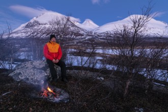 Man at the campfire, Stora Sjöfallet National Park, World Heritage Laponia, Norrbotten, Lapland,