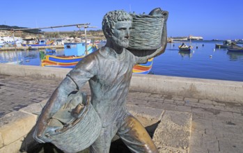 Fisherman statue sculpture in harbour at fishing village of Marsaxlokk, Malta, Europe