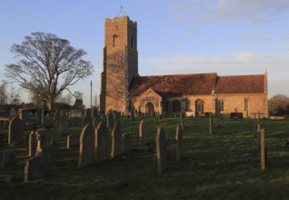 Late afternoon winter golden light falls on Saint John the Baptist church, Snape, Suffolk, England,