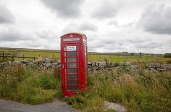 Red telephone box booth on moorland near Princetown, Dartmoor national park, Devon, England, UK