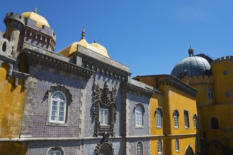 Part of a castle with yellow and grey facades, a dome and windows under a blue sky, Palácio