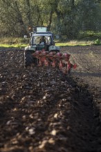 Farmer ploughing a field, tractor with plough, near Neuss, North Rhine-Westphalia, Germany, Europe