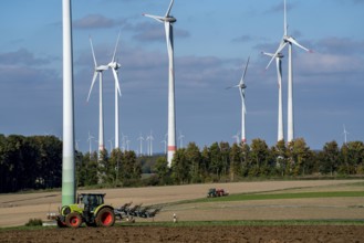 Farmer working in the fields, with a tractor, wind farm above the village of Lichtenau,