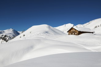 Snow-covered mountains and mountain hut with ski slope, Damüls, Bregenzerwald, Vorarlberg, Austria,