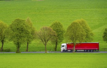 Lorry on a country road, green fields, meadows, trees line the 2-lane road, spring, near Schwelm,