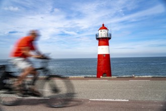 North Sea dyke near Westkapelle, Westkapelle Laag lighthouse, cyclists on the Zeeuwse Wind Route