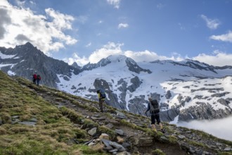 Mountaineers on a hiking trail, high fog in the valley, glaciated mountains with Furtschagelkees,