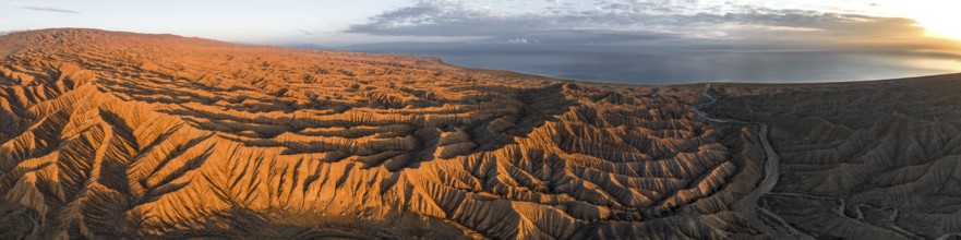 Panorama, landscape of eroded hills at Lake Issyk Kul, badlands at sunrise, aerial view, Canyon of