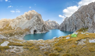 Green tent at the turquoise mountain lake Kol Suu with rocky steep mountains, Kol Suu Lake, Sary