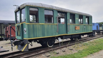 Green railway wagon with yellow details on a rail network, historical railcar, railway museum, Elk,