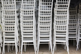 Close-up of stackeed white plastic armchairs in outdoor storage area, Kotor, Montenegro, Europe