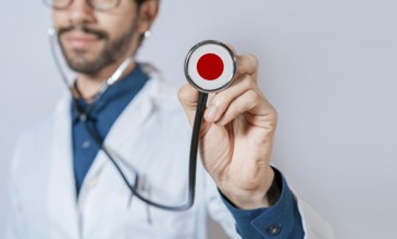 Doctor holding stethoscope with Japan flag. Japanese Health and Care Concept, Japan flag on