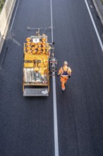 Marking work after the application of new whisper asphalt surface for the A40 motorway, in the