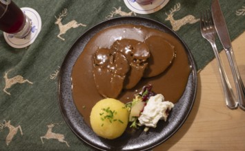 Roast beef with gingerbread sauce and dumplings, served in a Franconian inn, Bavaria, Germany,