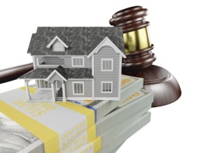 Miniature house with stack of money and wooden gavel isolated on a white background