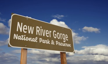 New river gorge national park and preserve (west virginia) road sign against blue sky and clouds