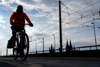 Cycling in the city, cyclist on the Deutzer Bridge in Cologne, Cologne Cathedral, cycle path, North