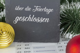 Board with the inscription CLOSED OVER THE HOLIDAYS on a calendar for 2025