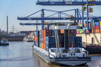 Container cargo ship enters the port basin of the Logport, gantry cranes in the Container Handling