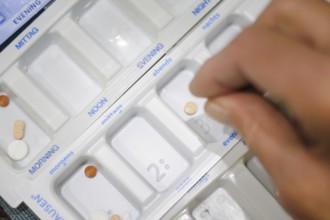 Symbolic photo on the subject of taking medication in old age. Two senior citizens sort various