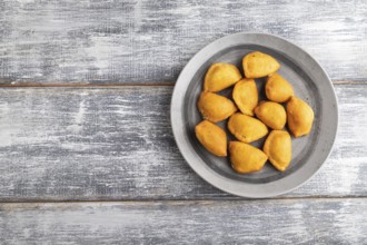 Fried dumplings on a wooden plate on a gray wooden background. Top view, flat lay, close up, copy