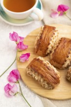 Traditional armenian dessert gata with cup of green tea on a gray concrete background and linen