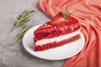 Homemade red velvet cake with milk cream and strawberry on a gray concrete background with red