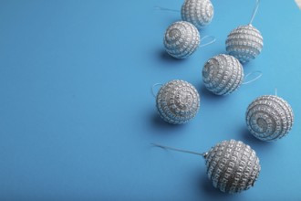 Christmas or New Year composition. Decorations, silver balls, on a blue paper background. Side