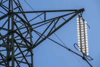 Insulators made of glass on a high-voltage line, they hang on the pylons as a suspension device