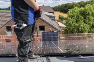 Installation of solar modules on the roof of a barn on a farm, over 210 photovoltaic modules are