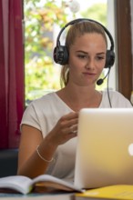 Young student learns at home, online, in conversation with other students