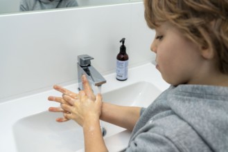 Domestic hygiene, washing hands with liquid soap, boy 9 years old