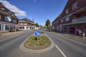 Traffic island with traffic sign for passing on the right on Weseler Strasse in Buldern, Dülmen,