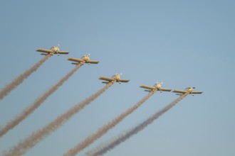 Stunt aerobatic planes performing stunts in blue sky with smoke trail. Concept of teamwork,