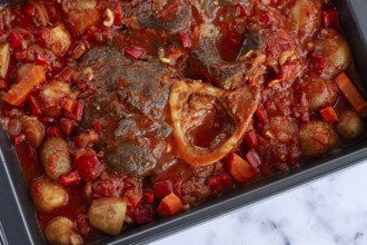 Ossobuco stew with vegetables, knuckle on the bone with new potatoes, in tomato sauce, homemade,