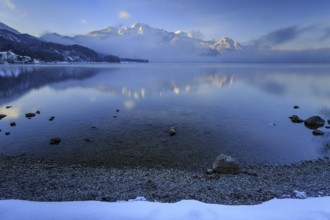 Mountains reflected in lake, morning light, fog, winter, snow, Lake Kochel, Alpine foothills,