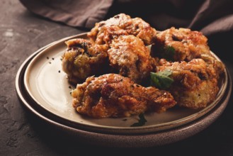 Fried chicken legs, breaded, with spices and herbs, on a dark background, horizontal, no people,