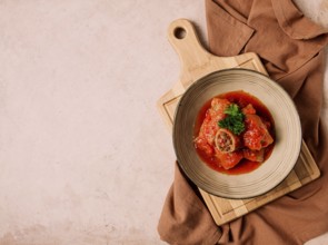 Stuffed cabbage rolls, with minced meat, in tomato sauce, on a beige background, food and drink,