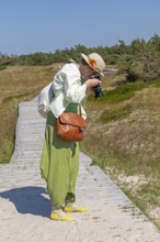 Woman photographed, wooden footbridge, trees, pine trees, circular hiking trail, nature reserve,