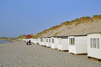 White beach huts along a wide sandy beach with dunes in the background, Lokken, Jutland, Denmark,