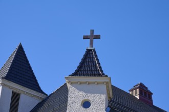 Church towers with cross and roof in front of a clear blue sky, Bryggen, Bergen, Vestland, Norway,