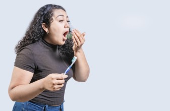 Young woman holding brush with bad breath isolated. Person with brush and bad breath isolated,