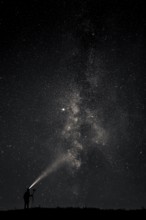 Photographer with tripod and headlamp light in a meadow with starry sky, Mindelheim, Unterallgäu,