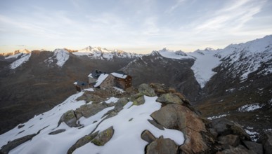 Snow-covered mountain landscape, mountain hut Ramolhaus in autumn with snow, at sunset, view of