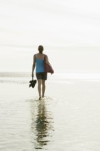 Woman walking through the mudflats, Wyk, Föhr, North Frisia, Schleswig-Holstein, Germany, Europe