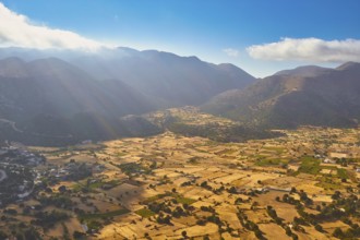 Wide fields and mountains under a clear sky with few clouds, Askifou Plateau, Lefka Ori, White