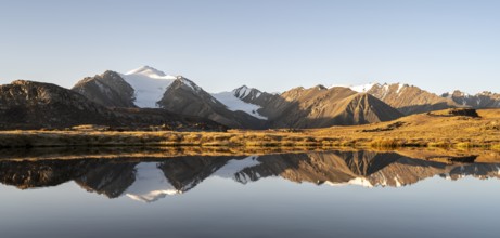 Glaciated mountain peaks reflected in a mountain lake at sunset, Arabel Lake at Arabel Pass, Issyk