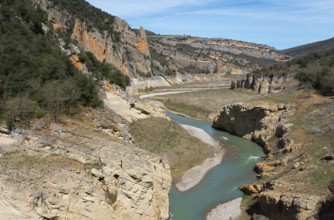 A river meanders through a deep gorge in the middle of a rocky landscape under a blue sky, Noguera