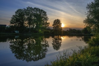 Evening sun reflected in a village pond, Mecklenburg-Western Pomerania, Germany, Europe