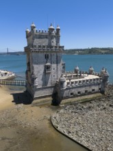 Historic tower on the rocky shore with a view of the sea and blue sky, aerial view, Torre de Belém,